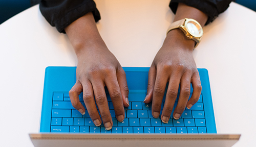 Close up of someone typing on a laptop